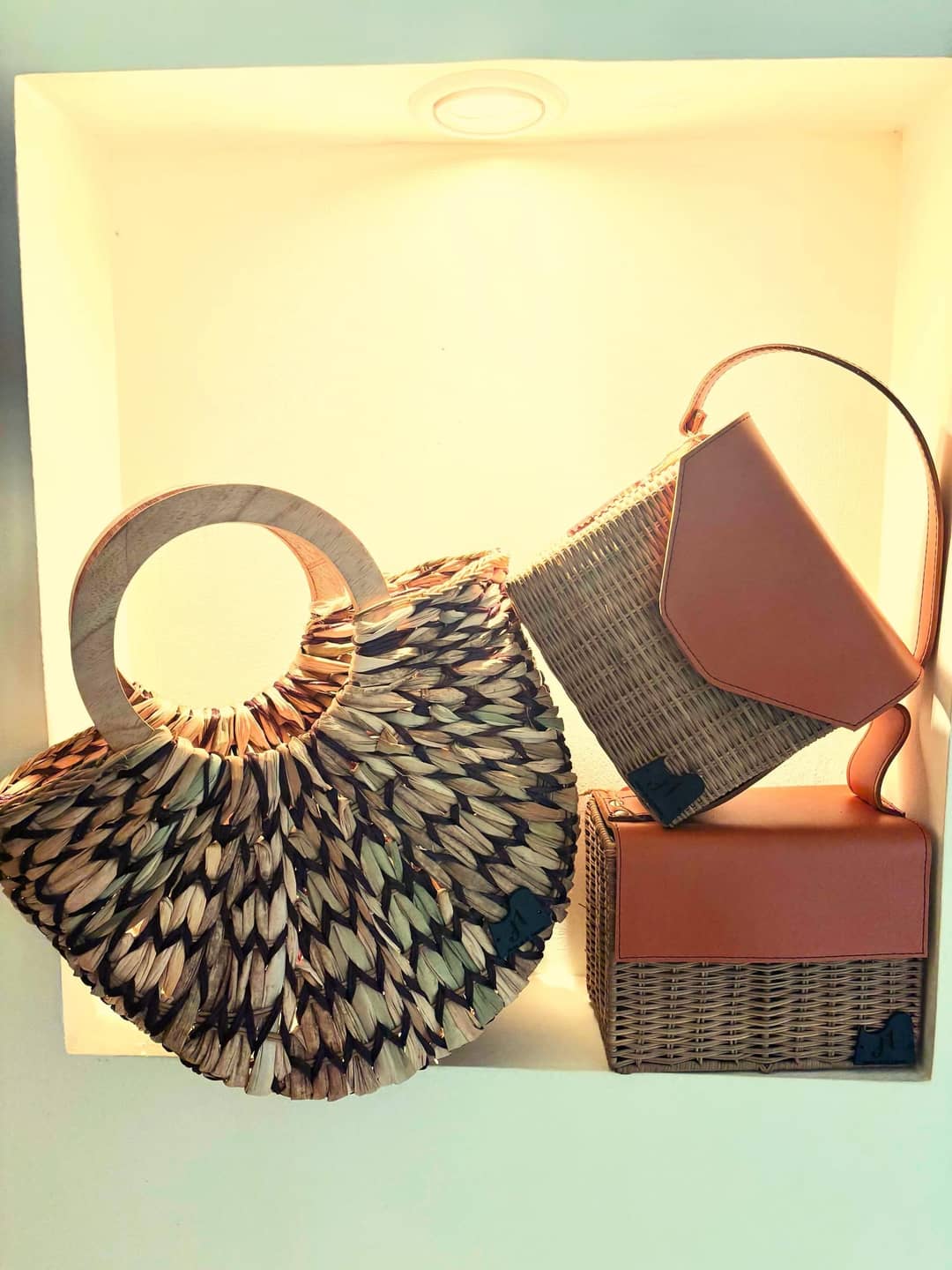 Carteras con asas de madera y detalles en cuero.